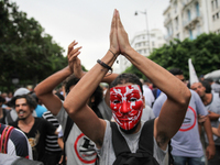 A protester wearing a mask applauds during a march held under the slogan ‘firmness against the mafia regime’ by the movement "I don't forgiv...
