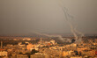 Smoke trails are seen as rockets are launched from the Gaza Strip towards Israel on August...