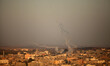 Smoke trails are seen as rockets are launched from the Gaza Strip towards Israel on August...