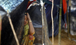 Rohingya refugees shelter from the rain in a camp in Cox’s Bazar, Bangladesh, on 15 Septem...