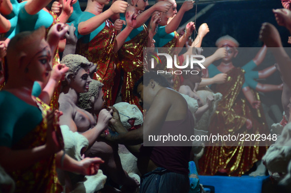 An indian artisan gives final touch to the clay idols of Indian hindu Goddess Durga ,in a workshop , ahead of Navratri and Durga pooja festi...