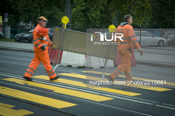 Road workers are seen removing road signs near a makeshift pedestrian crossing on World Car-Free Day on September 22, 2017. 