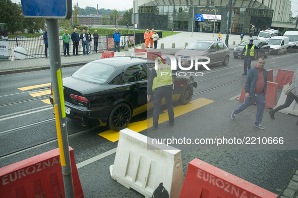 A man in an Alfa Romeo is seen being apprehended by police after failing to stop on time near a makeshift pedestrian crossing set up as part...