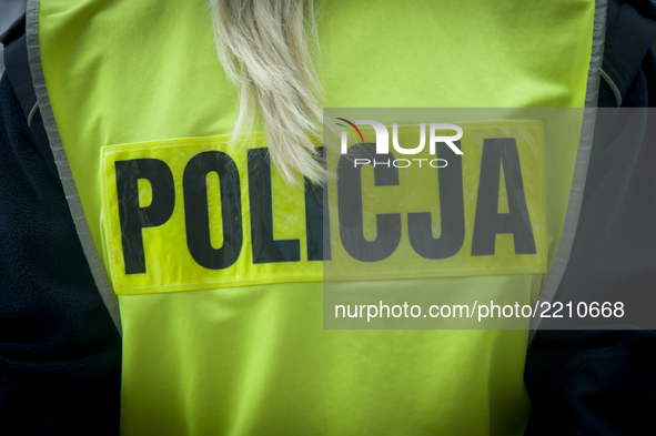 The Polish word for police is seen on the safety jacket of a female police officer on September 22, 2017. 