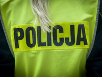 The Polish word for police is seen on the safety jacket of a female police officer on September 22, 2017. (
