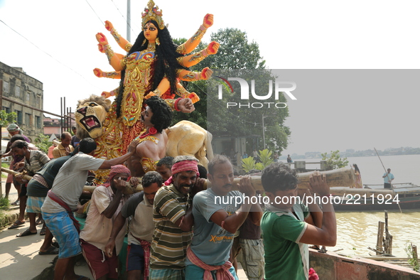 A clay statue of the Indian Hindu goddess Durga is transported from a workshop in Kumartoli, the idol makers' village, by boat on the river...