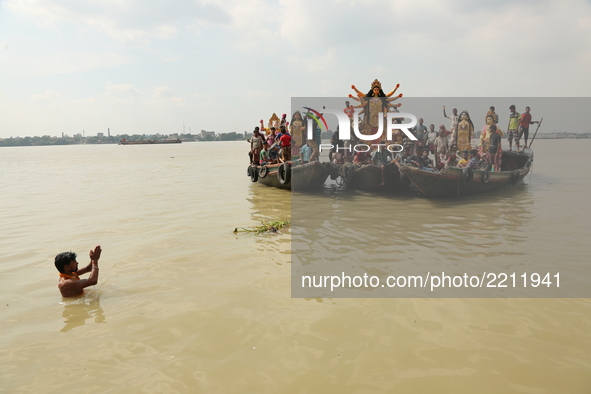 A clay statue of the Indian Hindu goddess Durga is transported from a workshop in Kumartoli, the idol makers' village, by boat on the river...