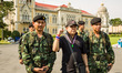 Soldiers pose with an Anti-Government protester on the lawn of Government House in Bangkok...