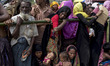 Rohingya refugees wait in a line for food aid at the Balukhali refugee camp in Ukhiya, Cox...