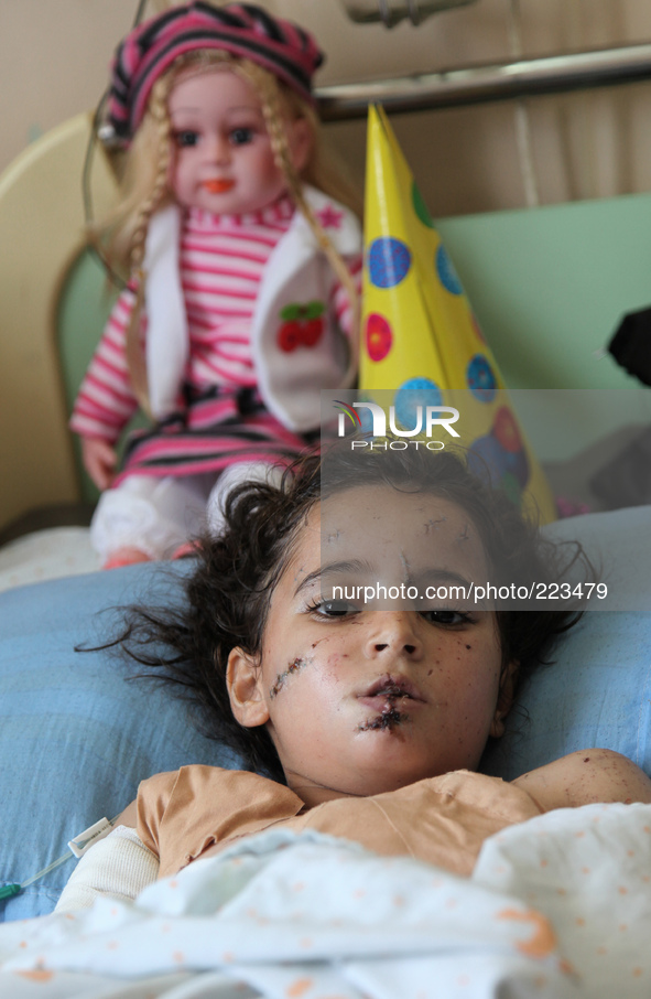 Lama Abu Hasira, 8 years, who lies on a bed at the Shifa hospital where she is undergoing treatment for shrapnel injury to her body. Heavy I...