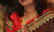 Bengali Hindu woman offering prayers during the Durga Puja festival at a pandal (temporary...
