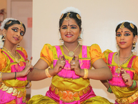 Bharatnatyam dancers practice an expressive dance backstage before a performance at a Tamil Hindu temple in Ontario, Canada. (