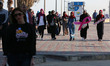 Palestinian women march on a street demonstration and carrying signs reading in Arabic ''U...