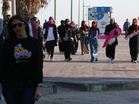 Palestinian women march on a street demonstration and carrying signs reading in Arabic ''Upright, walk'' (C-F), ''restore your youth by walk...