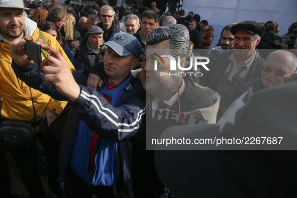 People take selfies with a man wearing the mask of Petro Poroshenko during a rally in front of Ukrainian Parliament. Mikheil Saakashvili gat...