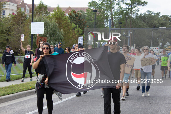 (171018) -- Gainesville, October 18, 2017 -- Anti-fascists carry a flag in front of protesters at the University of Florida in Gainesville,...