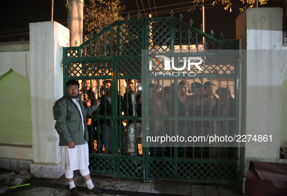 People wait outside a Shiite mosque named Imam-e-Zaman after an attack in Dasht-e-Barchi locality in Kabul, capital of Afghanistan, on Oct....