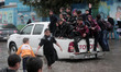 Palestinian school children walk in a flooded street during heavy rain in Gaza City on Nov...
