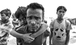 A newly arrived Rohingya refugee man carries her child after arriving at Shah Porir Dwip n...
