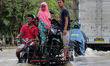 People pass through floods caused by heavy rainfall in North Aceh on December 2, 2017 in A...