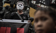 A protester wears a mask during Human Rights Day protests in Manila, Philippines, December...