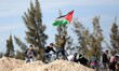 Palestinian protesters throw stones towards Israeli soldiers during a demonstration agains...