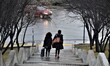 Two women walk on a narrow path with stairs during a rainy day in Ankara, Turkey on Decemb...