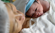 Mishela Lucas, 37, cradles her newborn son Kris Anthony Sarjos at a public hospital in Man...