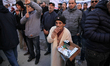 An elderly man sells cigarettes during the speech given by Noureddine Taboubi, general sec...
