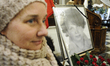 A woman is seen standing by a portrait of the late Jadwiga Kaczynska during the Holy Mass...