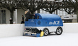 People looking on the ice resurfacer machine working on little ice rink are seen in winter...