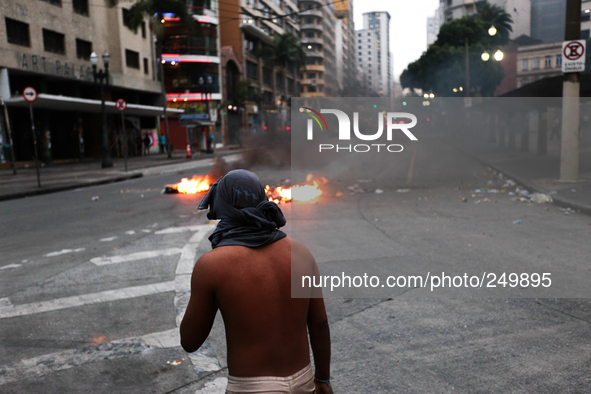 A man with a shirt on his face stands after an eviction ended in violent clashes in downtown Sao Paulo, Brazil on September 16, 2014. The ev...