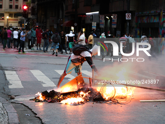 A protester sets fire to rubbish and scrap wood in the middle of the street after an eviction ended in violent clashes in downtown Sao Paulo...