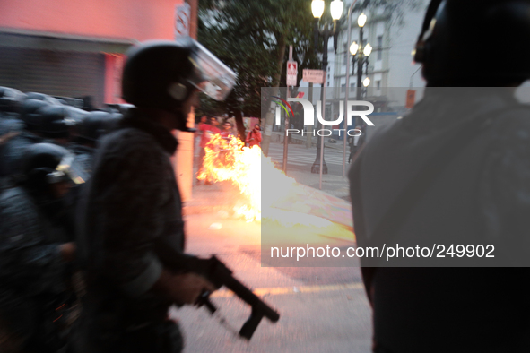 Riot police move through a street with a barricade on fire after an eviction ended in violent clashes in downtown Sao Paulo, Brazil on Septe...
