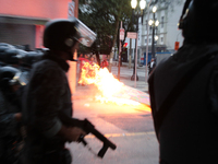 Riot police move through a street with a barricade on fire after an eviction ended in violent clashes in downtown Sao Paulo, Brazil on Septe...