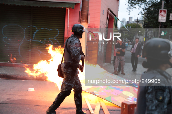 A riot police officer passes through a barricade on fire after an eviction ended in violent clashes in downtown Sao Paulo, Brazil on Septemb...