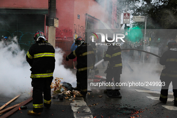 Firefighters try to extinguish the fire from barricades made ​​by protesters after an eviction ended in violent clashes in downtown Sao Paul...