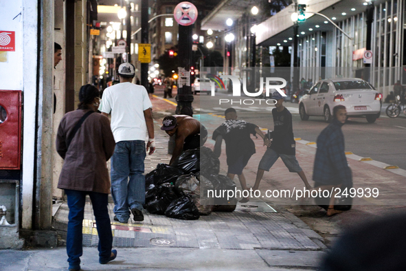 Young men take bags of garbage to throw them in the street after an eviction ended in violent clashes in downtown Sao Paulo, Brazil on Septe...