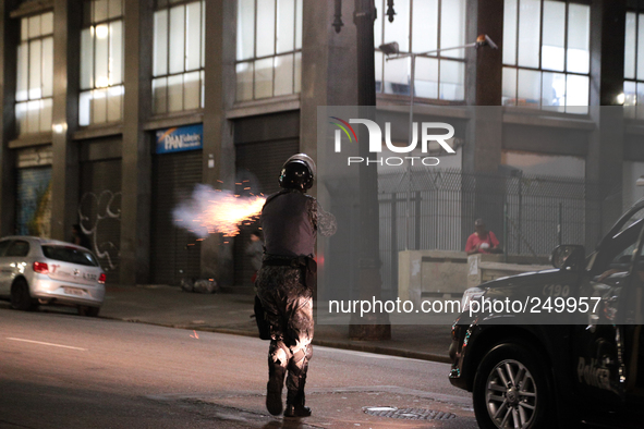 A riot police officer fires rubber bullets in an attempt to disperse people after an eviction ended in violent clashes in downtown Sao Paulo...