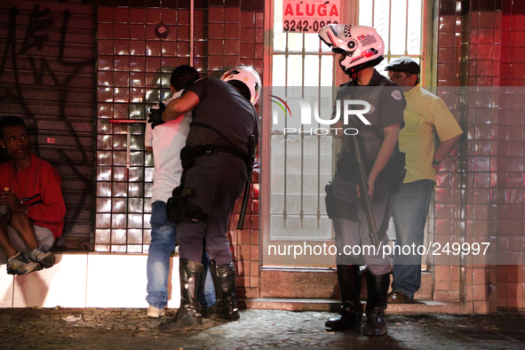 Riot police search a man while others watch after an eviction ended in violent clashes in downtown Sao Paulo, Brazil on September 16, 2014....