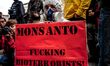 Protester wearing placard with slogans. Marches and rallies against seed giant Monsanto we...