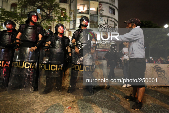 A man gestures to riot police after an eviction ended in violent clashes in downtown Sao Paulo, Brazil on September 16, 2014. The eviction o...