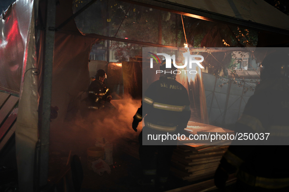 Firefighters try to put out the fire from a tent in the middle of a square after an eviction ended in violent clashes in downtown Sao Paulo,...