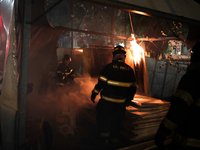 Firefighters try to put out the fire from a tent in the middle of a square after an eviction ended in violent clashes in downtown Sao Paulo,...