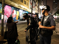 A woman asks a police officer for directions after an eviction ended in violent clashes in downtown Sao Paulo, Brazil on September 16, 2014....