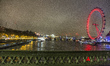 London Eye illuminated in red light, a giant Ferris over Thames River in London, UK on 19...