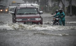 Motorists navigate a flooded road in Quezon city, suburban Manila, Philippines, September...
