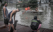Residents stay on a rooftop to escape rising floodwaters in Quezon city, suburban Manila,...