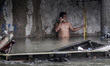 A resident uses his mobile phone in a flooded road in Quezon city, suburban Manila, Philip...