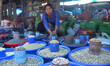 A woman sales varieties of spices and dry food bread in a market on the eve of Internation...